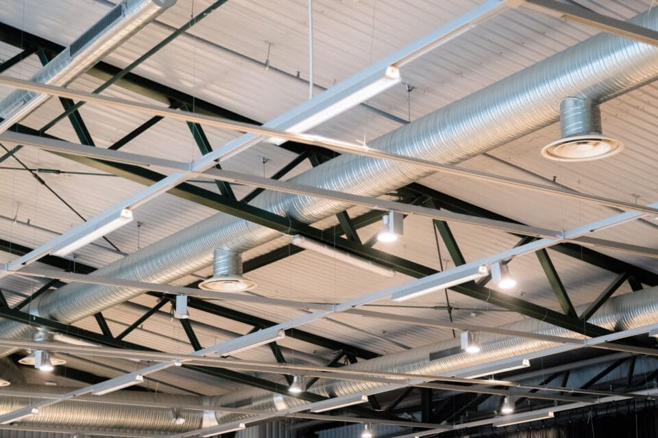 An Industrial-Style Ceiling Design Featuring Exposed Ventilation Pipes and Integrated Lighting