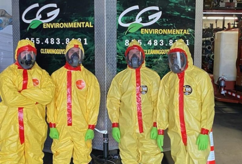 Hazmat team in protective suits standing in front of the CG Environmental signage